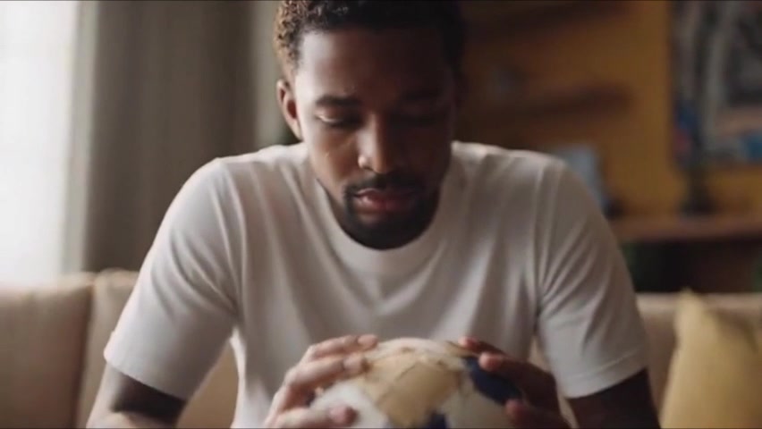 A man holding a worn football in the Men of Courage campaign film